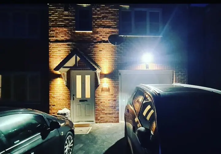 Brick-front house at night with illuminated porch and garage