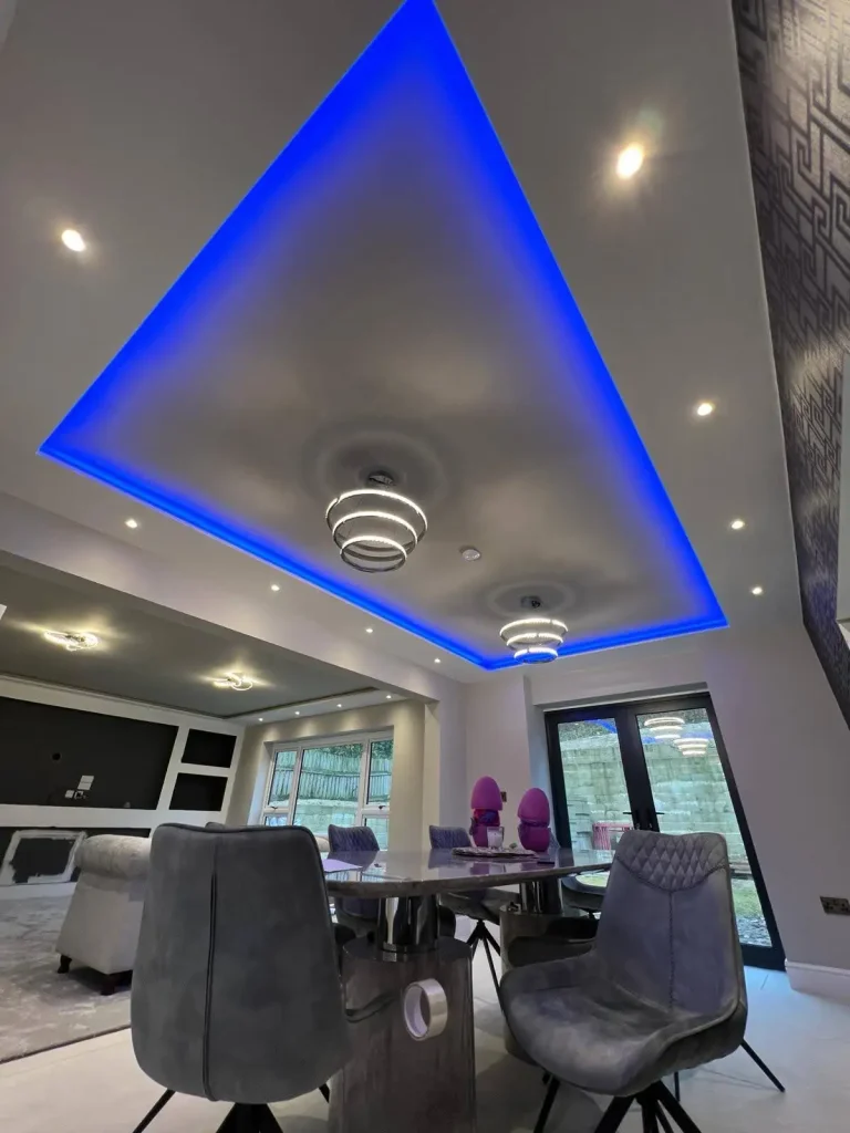 Contemporary dining and living area with blue LED ceiling lights