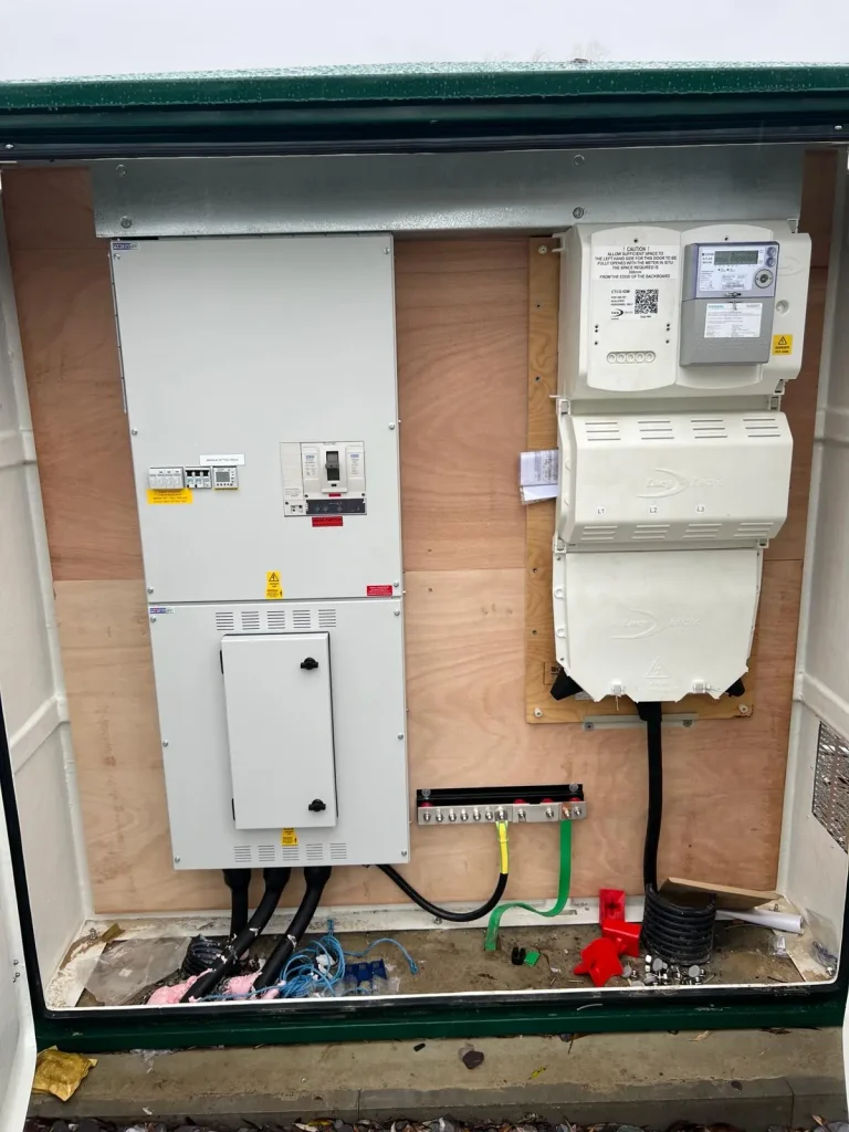 Electrical cabinet with white fuse panel, switches, and warning labels