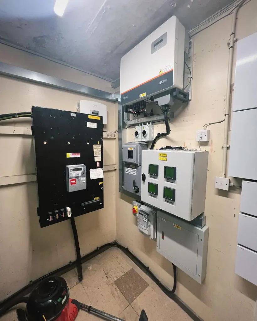 Electrical control room with inverter, monitoring panels, emergency stop button, and connected conduits