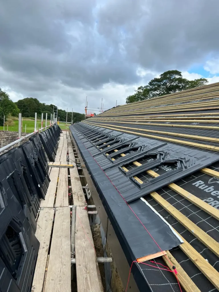 Rooftop with grid-pattern solar panel tiles integrated into black roofing system