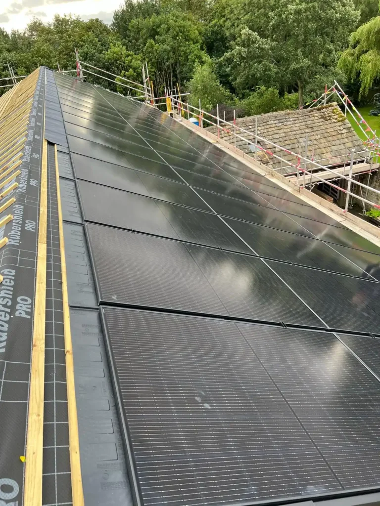 Rooftop with scaffolding and rows of solar panels installed over RAVERSHIELD PRO underlayment
