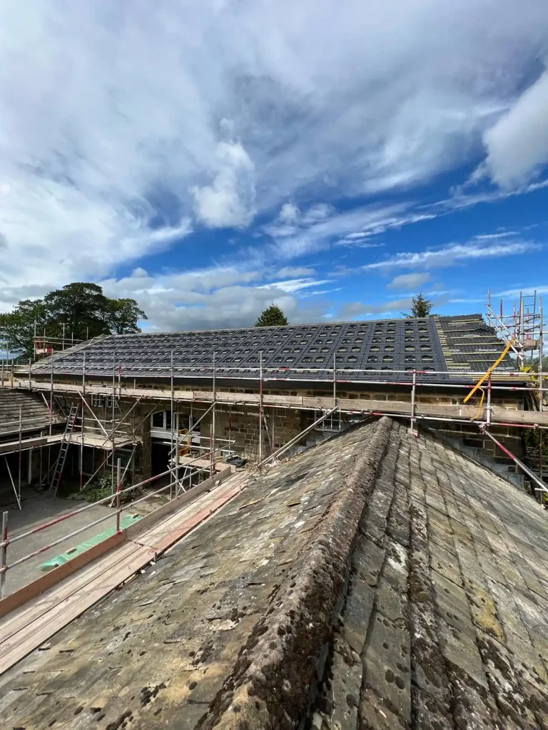 Construction site with scaffolding around building, showing rooftop with new solar panels